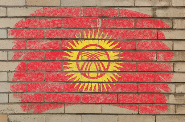Прапор Киргизстану на гранжевій цегляній стіні, пофарбованій крейдою — стокове фото