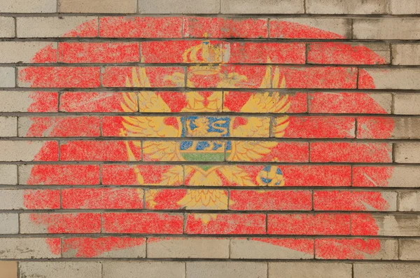 チョークで描かれた不潔なれんが造りの壁にモンテネグロの国旗 — ストック写真