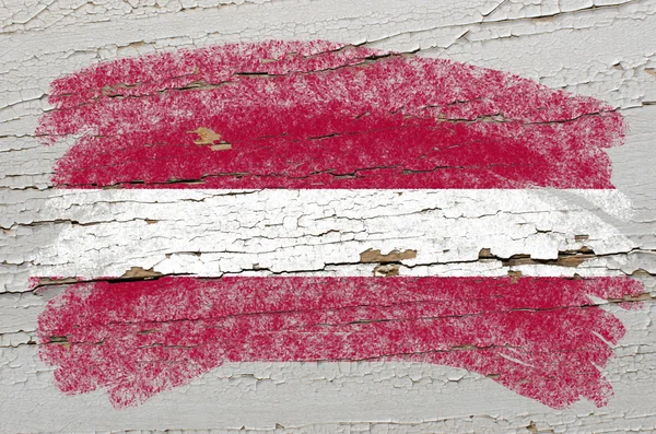 Lotyšská vlajka na grunge dřevěné textury namalované křídou — Stock fotografie