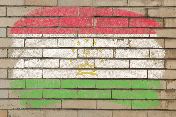 Bandera de Tayikistán en la pared de ladrillo grunge pintado con tiza — Foto de Stock