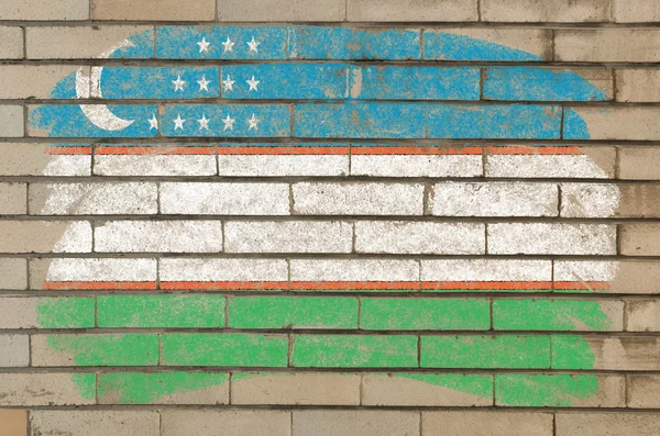Flag of uzbekistan on grunge brick wall painted with chalk — Zdjęcie stockowe