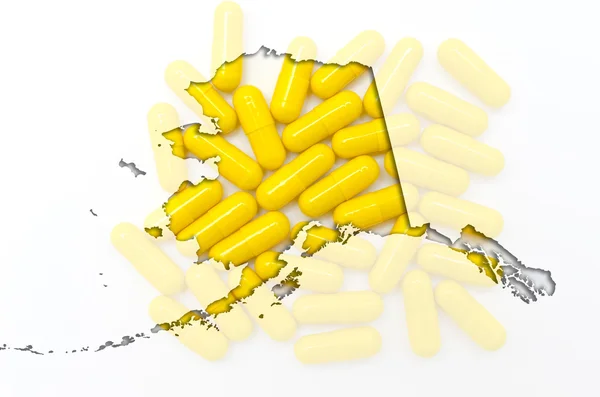 Outline Alaska map of with transparent pills in the background — Stock Photo, Image