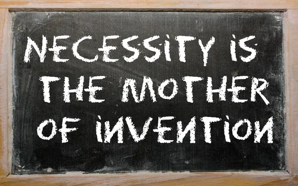 Provérbio "Necessidade é a mãe da invenção" escrito em um blac — Fotografia de Stock
