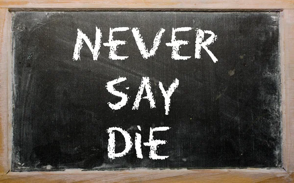 Ordspråket "aldrig säga die" skrivet på en svart tavla — Stockfoto