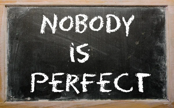 Ordspråket "ingen är perfekt" skrivet på en svart tavla — Stockfoto