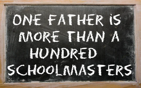 Proverb "One father is more than a hundred schoolmasters" writte — Stock Photo, Image