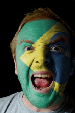Face of crazy angry man painted in colors of Brazil flag clipart