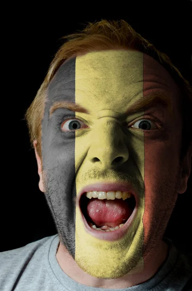 Gesicht eines verrückten wütenden Mannes in den Farben der belgischen Flagge gemalt — Stockfoto