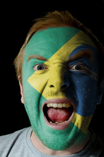 Gezicht van gek boze man geschilderd in kleuren van de vlag van Brazilië — Stockfoto