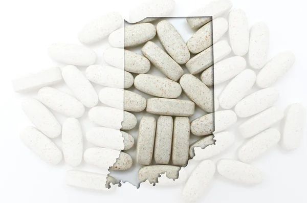 Outline map of Indiana with transparent pills in the background — Stock Photo, Image