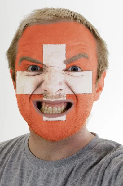 Face of crazy angry man painted in colors of Schwitzerland flag — Stock Photo, Image
