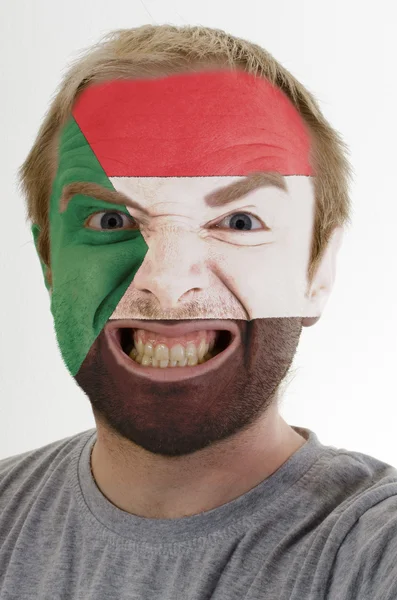 Volto di pazzo arrabbiato uomo dipinto nei colori della bandiera del Sudan — Foto Stock