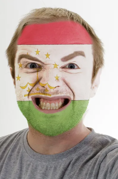 Face of crazy angry man painted in colors of Tajikistan flag — Stock Photo, Image