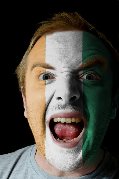 Face of crazy angry man painted in colors of Cote'd Ivore flag — Stock Photo, Image