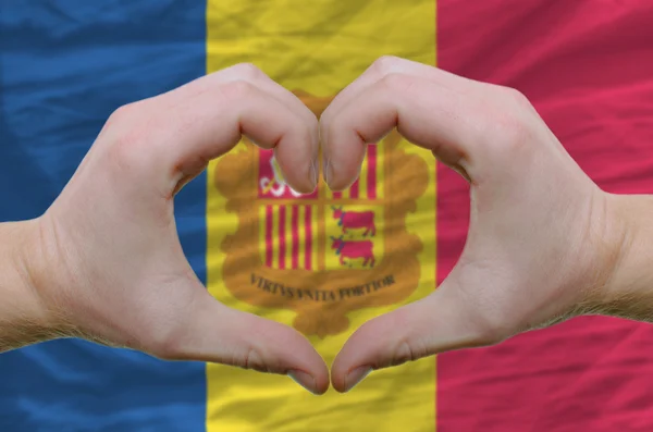 Жест любви и сердца, показываемый руками над флагом Андоры — стоковое фото