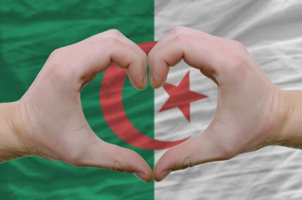 Hart en liefde gebaar toonde door handen over de vlag van afghanistan — Stockfoto