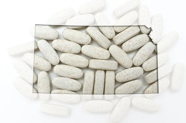 Konturkarta över kansas med transparent piller i bakgrunden — Stockfoto
