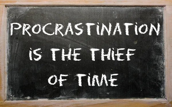 Proverbio "Procrastinación es el ladrón del tiempo" escrito en un blac Fotos de stock libres de derechos