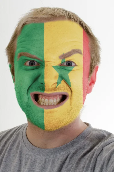 Volto di pazzo arrabbiato uomo dipinto nei colori della bandiera senegalese — Foto Stock
