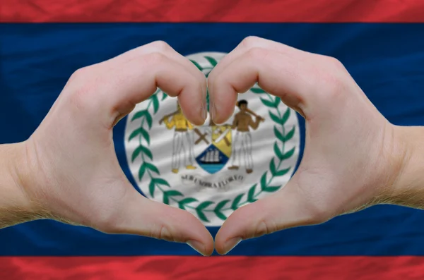 Жест любви и сердца, показанный руками над флагом Белиза — стоковое фото