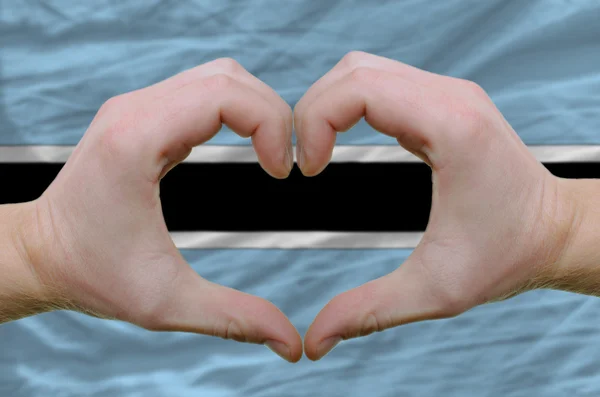Geste de coeur et d'amour montré par les mains sur le drapeau du Botswana bac — Photo