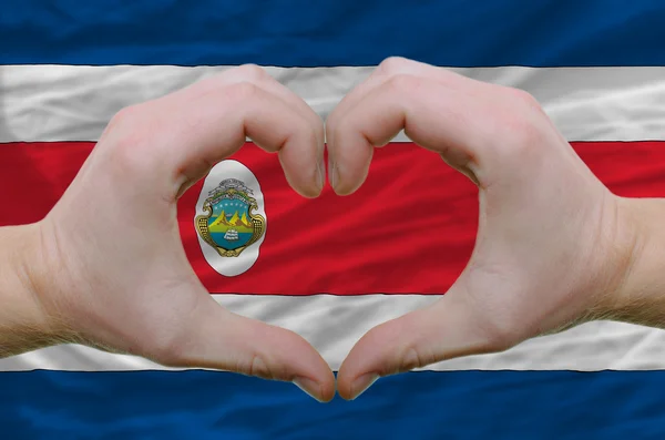 Srdce a lásku gestem ukázal rukou nad vlajkou Kostariky b — Stock fotografie