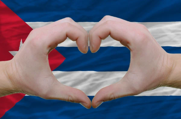 キューバの backgro の旗の上の手によって示した心と愛のジェスチャー — ストック写真