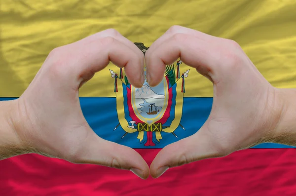 Srdce a lásku gestem ukázal rukou nad vlajka Ekvádoru zpět — Stock fotografie