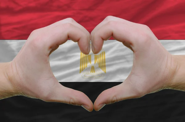 Srdce a lásku gestem ukázal rukou nad vlajka Egypta pozadí — Stock fotografie