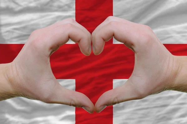 Hart en liefde gebaar toonde door handen over de vlag van Engeland terug — Stockfoto