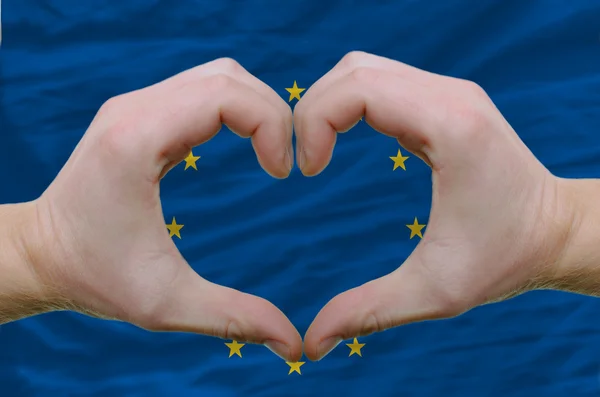 Szív és a szeretet gesztusa azt mutatta, kezében háttere eu zászlaja alatt — Stock Fotó
