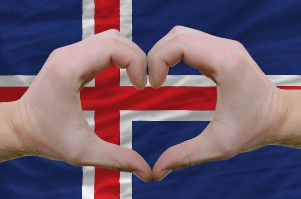 Kalp ve sevgi jest eller tarafından İzlanda arka bayrak üzerinde gösterdi. — Stok fotoğraf