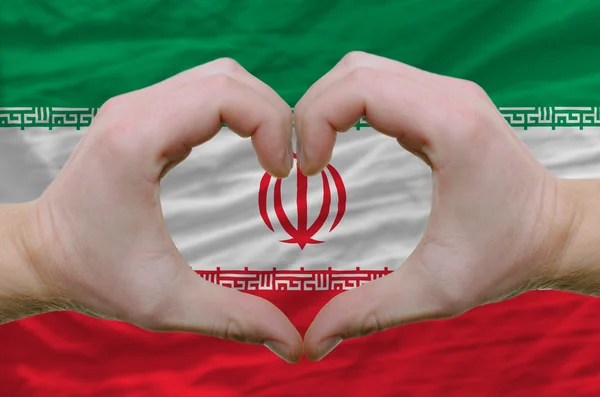Srdce a lásku gestem ukázal rukou nad vlajkou Íránu backgro — Stock fotografie