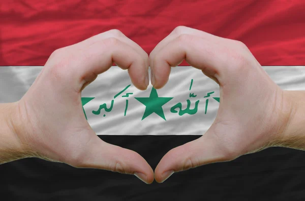 Srdce a lásku gestem ukázal rukou nad vlajka Iráku backgro — Stock fotografie