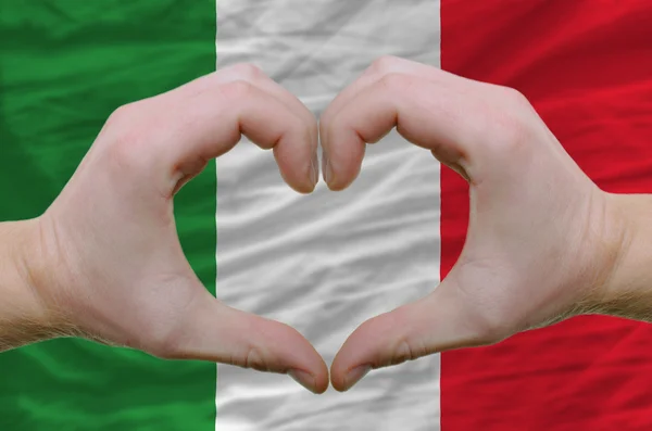 Hart en liefde gebaar toonde door handen over vlag van Italië backgr — Stockfoto