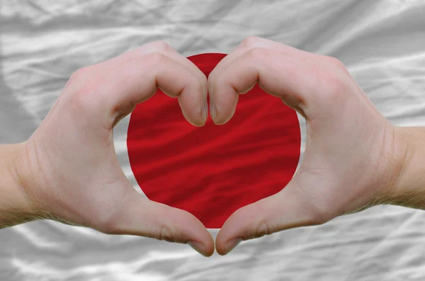 Corazón y el amor gesto mostrado por las manos sobre la bandera de Japón backgr — Foto de Stock