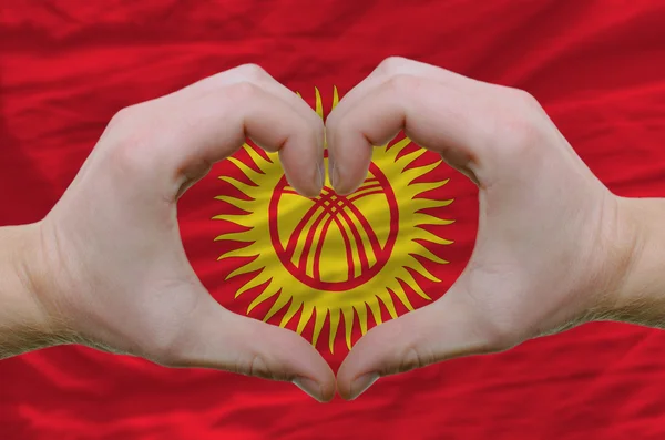 Kalp ve sevgi jest kyrghyzstan bayrağı üzerinde eller tarafından gösterdi — Stok fotoğraf