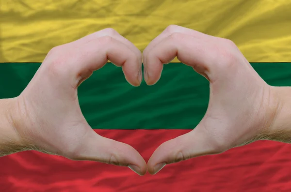 Жест любви и сердца, показываемый руками над флагом Литуании ба — стоковое фото