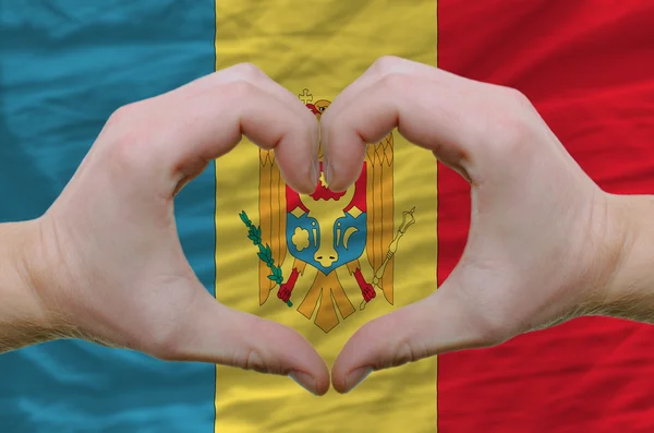 Srdce a lásku gestem ukázal rukou nad vlajkou Moldavsko zpět — Stock fotografie