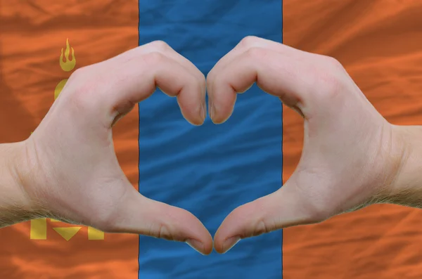 Hart en liefde gebaar toonde door handen over de vlag van Mongolië bac — Stockfoto