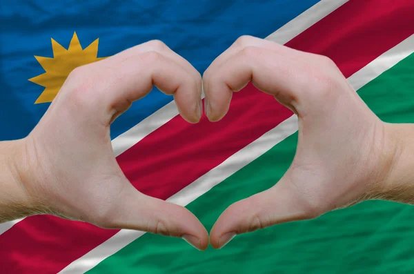 Hart en liefde gebaar toonde door handen over de vlag van Namibië terug — Stockfoto
