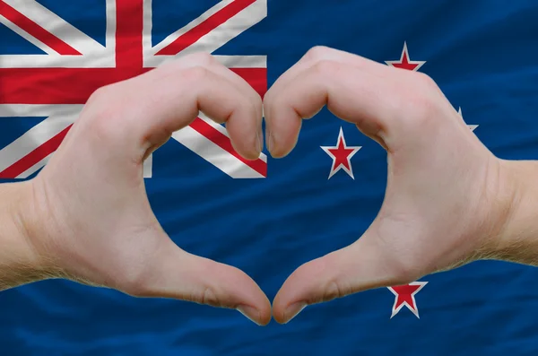 Gesto del cuore e dell'amore mostrato dalle mani sopra la bandiera della Nuova Zelanda — Foto Stock