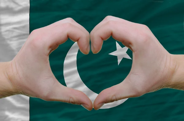 Srdce a lásku gestem ukázal rukou nad vlajka Pákistánu bac — Stock fotografie