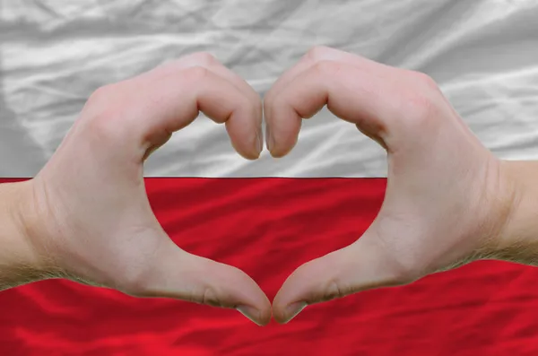 Geste de coeur et d'amour montré par les mains sur le drapeau de poland backg — Photo