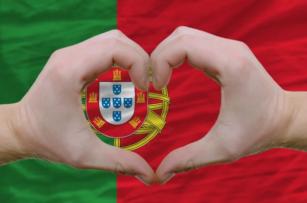 Srdce a lásku gestem ukázal rukou nad vlajkou Portugalska bac — Stock fotografie