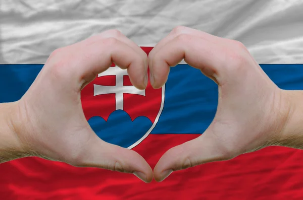 Srdce a lásku gestem ukázal rukou nad vlajka Slovenska bac — Stock fotografie