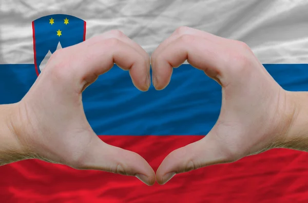 Srdce a lásku gestem ukázal rukou nad vlajka Slovinska bac — Stock fotografie