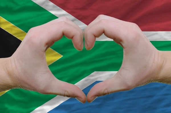 El corazón y el gesto de amor mostrados por las manos sobre la bandera de Sudáfrica —  Fotos de Stock