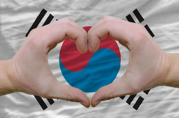 Cuore e amore gesto mostrato dalle mani sopra la bandiera della Corea del Sud — Foto Stock