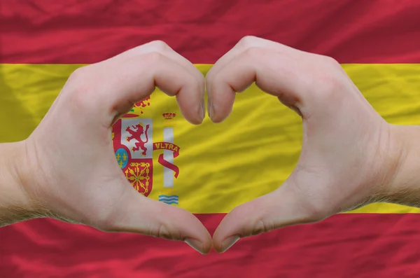 Srdce a lásku gestem ukázal rukou nad vlajkou Španělska pozadí — Stock fotografie